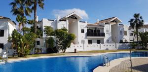 Villa con piscina frente a un edificio en A Golf & Beach chez Pascale et Alain en Alcaidesa