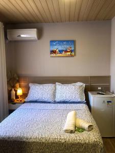 Un dormitorio con una cama con una colcha blanca. en Suites da Lu, en Penha