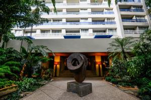 um grande edifício com uma estátua em frente em HOTEL ALTAMIRA SUITES em Caracas