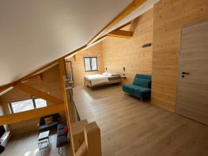 an attic room with a bed and a room with a staircase at Les Chalets des Capucines & Jacuzzi privatif in Rochesson