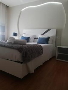 um quarto com uma grande cama branca com almofadas azuis em Hotel Termas em Chaves