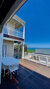 a deck with a table and a balcony with the ocean at Beautiful beach house on Prince's Grant Estate in Blythedale
