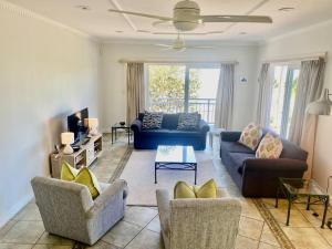 a living room with two couches and a tv at Beautiful beach house on Prince's Grant Estate in Blythedale