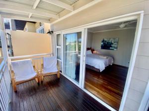 a bedroom with a bed and a balcony at Beautiful beach house on Prince's Grant Estate in Blythedale