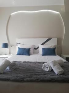 a white bed with blue pillows and towels on it at Hotel Termas in Chaves +45 photos