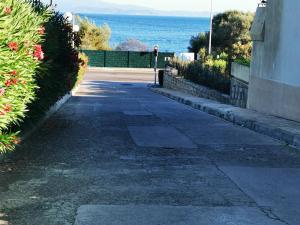 una persona caminando por una acera junto al océano en Appartement Ajaccio Sanguinaires en Ajaccio