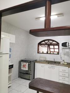 a kitchen with white cabinets and a stove top oven at Casa Cabo Frio in Cabo Frio