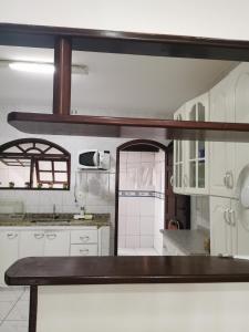 a kitchen with white cabinets and a table in it at Casa Cabo Frio in Cabo Frio