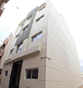 a tall white building with a window at Karama Star Residence (Home Stay) in Dubai