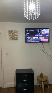 a room with a black dresser and a tv on a wall at BvApartments Queensgate 4 in Huddersfield