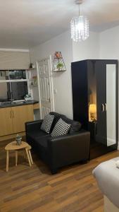 a living room with a black couch and a table at BvApartments Queensgate 4 in Huddersfield