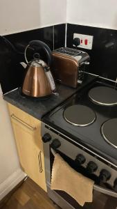 a tea kettle sitting on top of a stove at BvApartments Queensgate 4 in Huddersfield