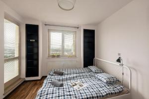 a bedroom with a bed with a plaid blanket at Pokoje Bukowińska in Warsaw