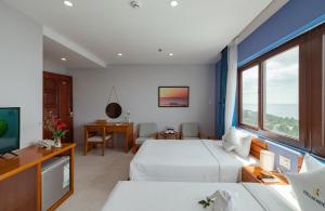 een hotelkamer met twee bedden en een televisie bij Stellar Hotel in Phu Quoc +50 foto's