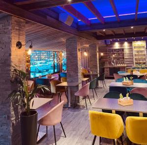 un restaurante con mesas y sillas y un bar en Hotel Le Panorama, en Le Mont-Dore