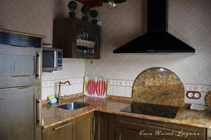 a kitchen with a sink and a refrigerator at Casa Begoña in Igüeña