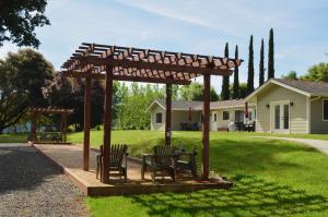 a pergola with chairs and a table in a yard at Indian Creek Inn in Philo