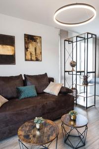 sala de estar con sofá marrón y 2 mesas en Stylisches Apartment im Herzen von Dresden + Parkplatz + Netflix + Self Check-in, en Dresden