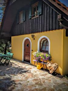 a yellow house with flowers in front of it at Ferienhaus Pfarrerweinzerl in absoluter Ruhelage mit Pool in Kitzeck im Sausal