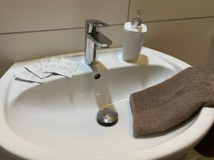 a bathroom sink with a towel and a faucet at Hotel Kolossos Düsseldorf - Neuss in Neuss