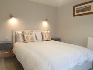a bedroom with a large white bed with pillows at No8 3 bed cottage Winter Deals offered 3 nights or more Nov-Mar in Backbarrow