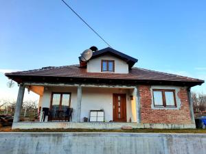 una pequeña casa de ladrillo con techo marrón en Kuća na dan Vrla strana en Bosansko Petrovo Selo