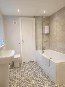 a bathroom with a tub and a toilet and a sink at No8 3 bed cottage Winter Deals offered 3 nights or more Nov-Mar in Backbarrow