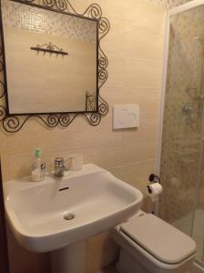 y baño con lavabo, espejo y aseo. en villa verde bed and breakfast, en Uggiate