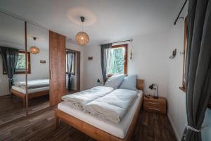 a bedroom with a large bed and a mirror at Sommerhaus am Nationalpark Eifel mit Sauna in Monschau