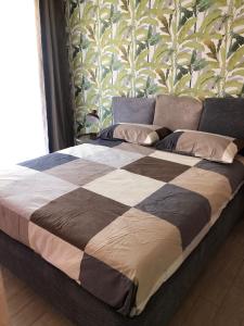 ein großes Bett in einem Schlafzimmer mit einer Wand in der Unterkunft E&C Suites Roma in Lido di Ostia