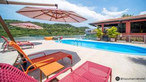 uma piscina com cadeiras e guarda-sóis ao lado de uma piscina em Rizzu Marina Hotel em Balneário Camboriú