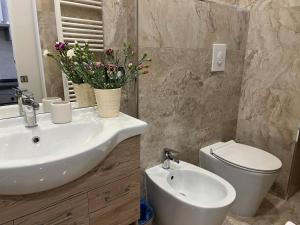 a bathroom with a sink and a toilet with flowers at Casa Morganti- in Sesto San Giovanni