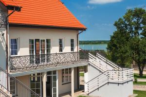 une vue extérieure sur une maison avec un toit orange dans l'établissement Apartamenty M&M, à Mikołajki