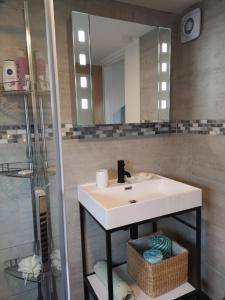 La salle de bains est pourvue d'un lavabo blanc et d'une douche. dans l'établissement Offa Home, à Leamington Spa