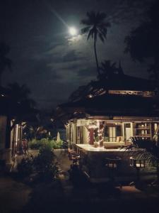 a house with a palm tree and a full moon at Niramaya Villa & Wellness in Ko Yao Noi