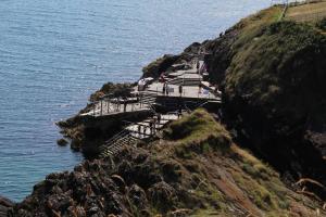un grupo de escaleras en un acantilado junto al océano en Seacourt Accommodation Tramore - Adult Only, en Tramore