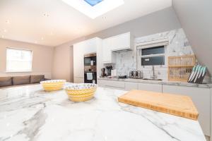 una cucina con armadi bianchi e un ampio pavimento in marmo di Stunning Hyde Park Apartments a Londra