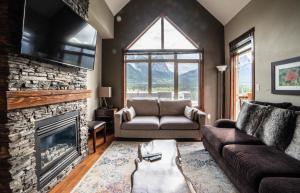 a living room with a couch and a fireplace at Spacious Penthouse Suite-king Beds-pool & Hot Tub in Canmore