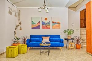 un soggiorno con divano blu e alcune piante di Ulivo Sea View House a Kokkíni Khánion