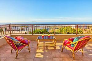 a patio with two chairs and a table on a balcony at Ulivo Sea View House in Kokkíni Khánion
