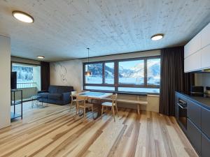 a kitchen and living room with a table and chairs at DER*ADLER Apartments in Schoppernau