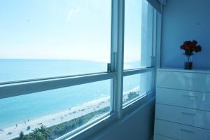 Cette chambre dispose d'une fenêtre offrant une vue sur la plage. dans l'établissement Oceanfront condo with ocean view beach, bar, free parking and gym!, à Miami Beach