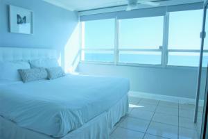 מיטה או מיטות בחדר ב-Oceanfront condo with ocean view beach, bar, free parking and gym!