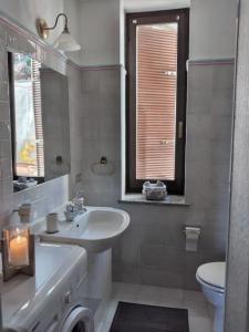 bagno con lavandino, servizi igienici e specchio di Maison Al Nocino a Stresa