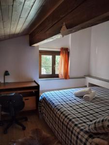 una camera con letto, scrivania e sedia di Maison Al Nocino a Stresa
