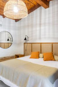 ein Schlafzimmer mit einem großen Bett mit orangefarbenen Kissen in der Unterkunft Gardenia in San Javier