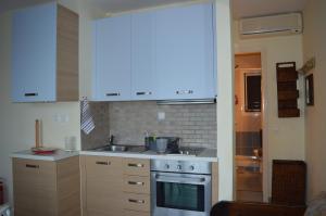 a kitchen with a sink and a stove at Glyfada New Era Home 120 Menigos Resort Apartments in Glyfada