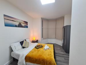 a bedroom with a large bed with a yellow blanket at Property Malak Homz - West Street 2 Bed Premium Apartment in Leicester