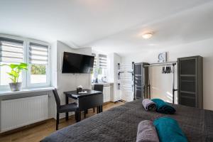 a bedroom with a bed and a desk and a television at revLIVING Apartments Eggenburg - Garten - Netflix - Disney Plus - Nespresso in Eggenburg