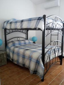 a bedroom with a bunk bed with a plaid blanket at Camino al Mar in Santa Cruz Huatulco